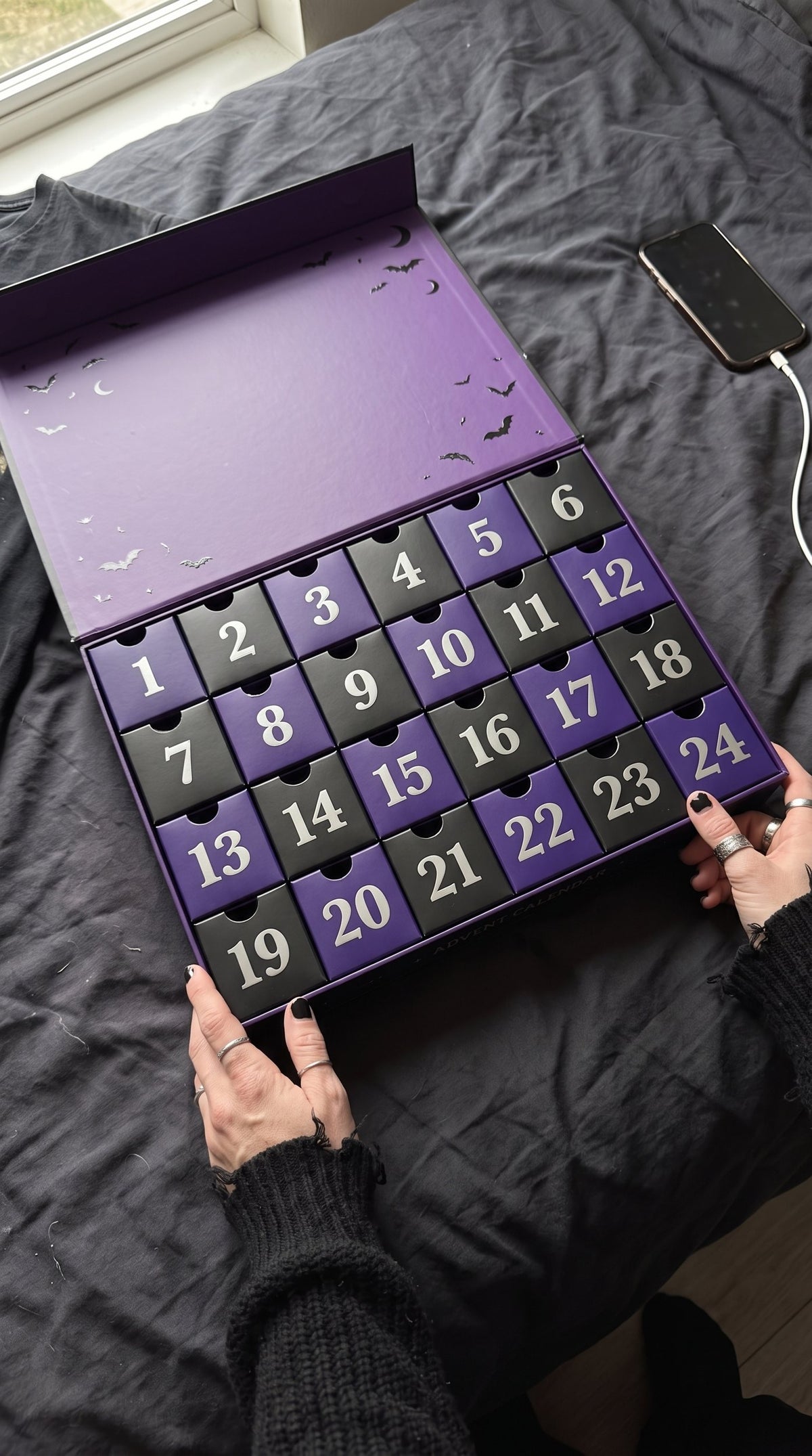 Open advent calendar with 24 numbered black and purple boxes